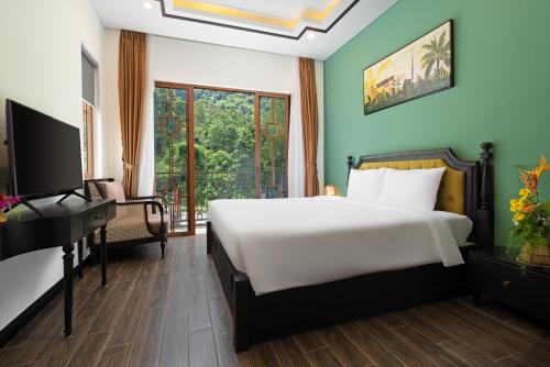 a bedroom with a bed and a desk and a television at Fivitel Cổng Trời Đông Giang - Fivitel Đông Giang Heaven's Gate in Dong Giang