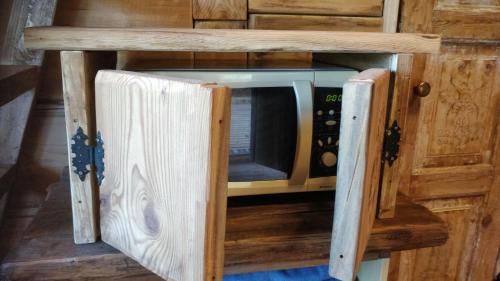 a microwave oven sitting inside of a wooden cabinet at Uneallika hubane saunaga majake "Hoburaud" in Pae