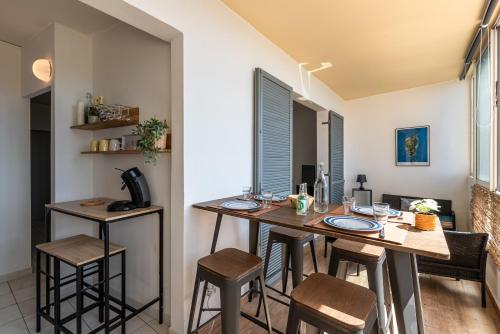 une cuisine et une salle à manger avec une table et des chaises dans l'établissement Les crêtes , magnifique T2 4 pers Route des Sanguinaires, à Ajaccio