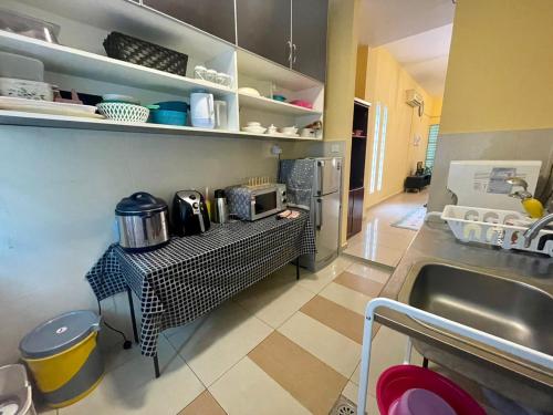 a kitchen with a counter with a sink and a counter sidx sidx sidx at Homestay Raudhah, Taman Gombak Ria in Batu Caves