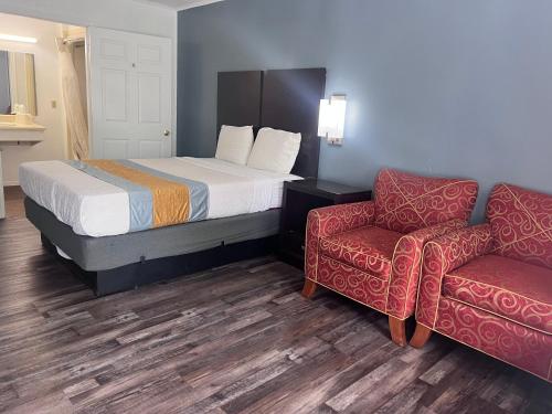 a hotel room with a bed and a chair at Smith Motel in Calhoun