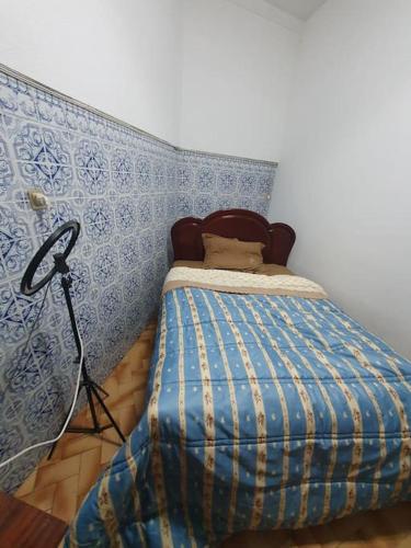 a bedroom with a bed with a blue wall at Casa T1 em Alverca. in Arsena
