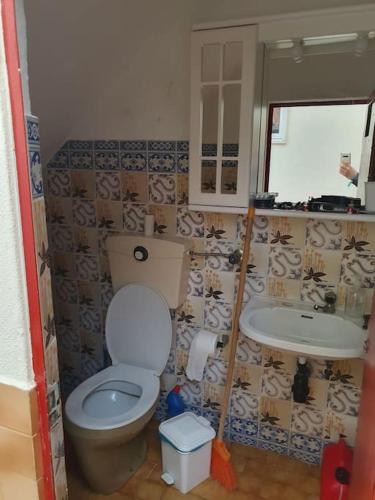 a bathroom with a toilet and a sink at Casa T1 em Alverca. in Arsena