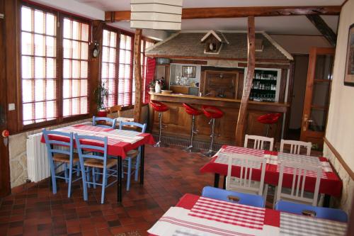 a restaurant with red and blue tables and chairs at Le Pingouin in Bennecourt