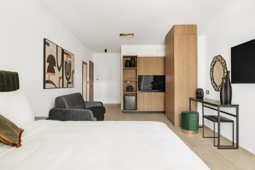 Cens Silver Luxury Suites في يوانينا: غرفة نوم مع سرير وغرفة معيشة