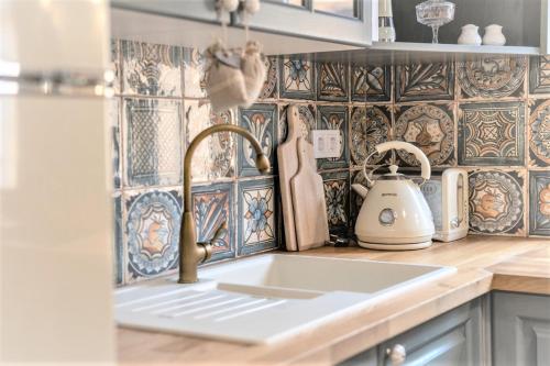 a kitchen with a sink and a counter top at Nanica Vendégház - Vidéki romantika in Buzsák