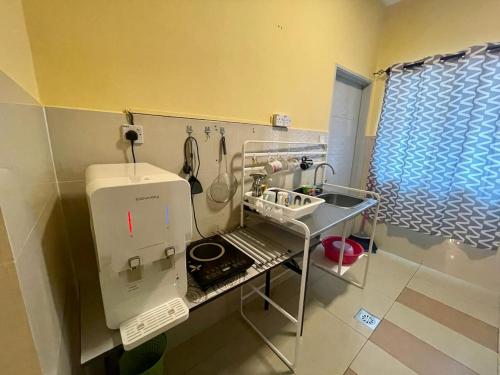 een kleine keuken met een naaimachine in een kamer bij Homestay Raudhah, Taman Gombak Ria in Batu-grotten