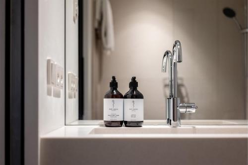 Dos botellas de vino sentadas en el lavabo del baño en HApato, en Múnich