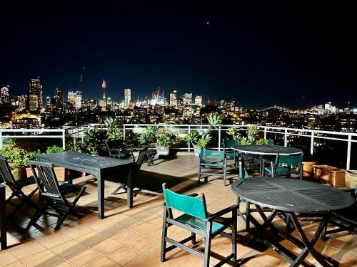 a deck with tables and chairs and a view of a city at Studio in Darling Point in Sydney