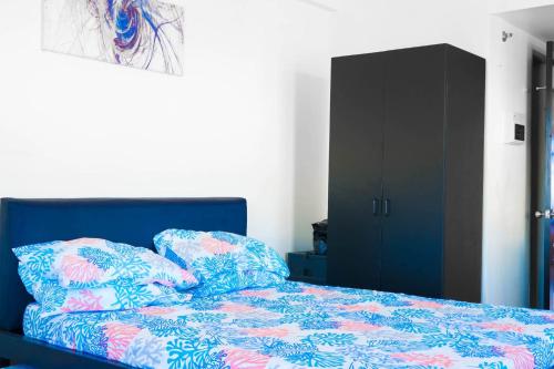 - une chambre avec un lit bleu et une armoire noire dans l'établissement Mabolo Garden Flat, à Cebu