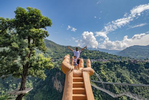 a man and a child standing on the end of a roller coaster at The Cliff Resort Pokhara Kushma in Kusma