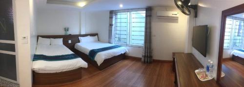 um quarto de hotel com duas camas e uma televisão em Hoa Đào Hotel em Sapa