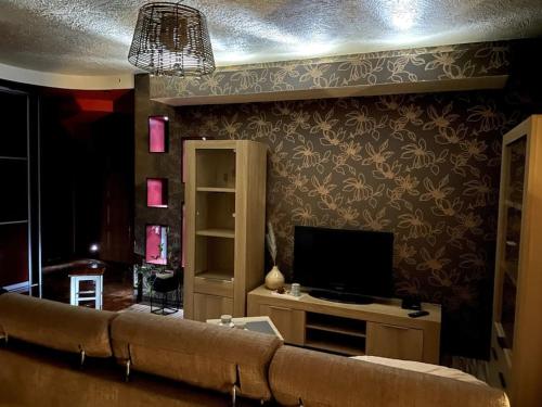ein Wohnzimmer mit einem Sofa und einem TV in der Unterkunft Apartament Moniuszki in Biłgoraj