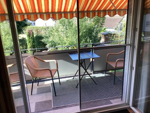 Lauchringen的住宿－Schöne Ferienwohnung Nähe der Schweizer Grenze，阳台设有2把椅子和1张桌子,门廊上设有