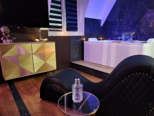 a table with a bottle of water sitting on a chair at Caen, Tu m'aimes - Suite Romantique in Caen