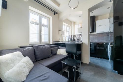 un salon avec un canapé et une cuisine dans l'établissement Apartament Ale Antresola! - 4 osobowy przy ratuszu z parkingiem - Space Apart, à Jelenia Góra