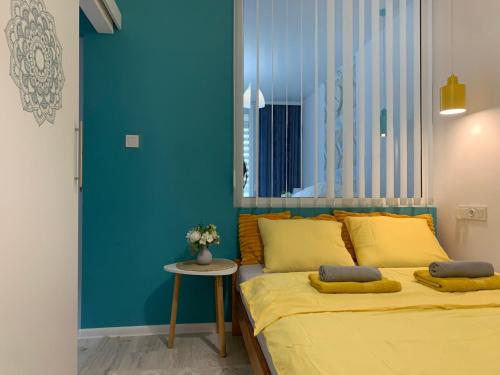 a bedroom with a bed and a blue wall at Apartament UNEZKO in Gdańsk