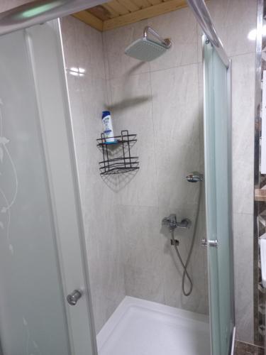 a bathroom with a shower with a glass door at Saklı Bahçe Suite in Uzungöl