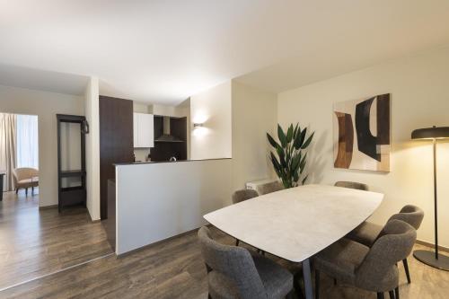 Dukes' Apartments Grand Place في بروج: غرفة طعام مع طاولة وكراسي