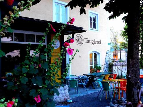 a building with a table and chairs in front of it at Tauglerei Appartement Enzian in den Zauberbergen in Sankt Koloman
