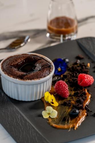 a chocolate dessert on a plate with berries and a drink at Cresanto Luxury Suites in Imerovigli
