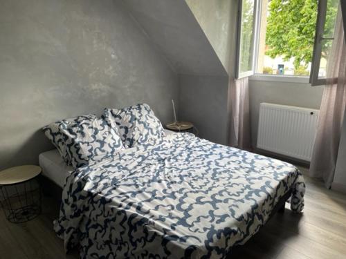 - une chambre dotée d'un lit avec une couverture bleue et blanche dans l'établissement Chambre privée - Proche Disney - Sans repas, à Bussy-Saint-Georges