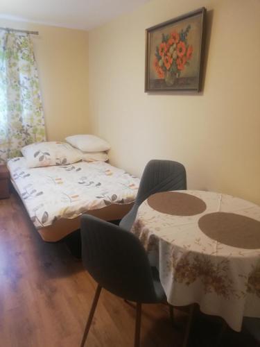 Cette petite chambre comprend un lit et deux tables. dans l'établissement Luna, à Wisełka