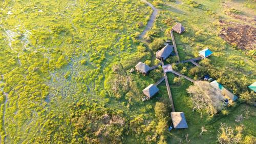 an aerial view of a group of houses in a field at Little Okavango Camp Serengeti, A Tent with a View Safaris in Itonga
