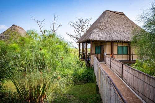 una piccola capanna con tetto di paglia e recinzione di Little Okavango Camp Serengeti, A Tent with a View Safaris a Itonga