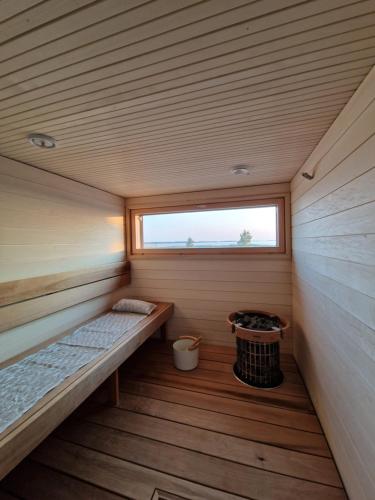 a small sauna with a window in a wooden cabin at Beach house in Kalajoki