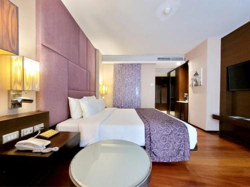a hotel room with a large bed and a toilet at Citichic Sukhumvit 13 by Compass Hospitality in Bangkok