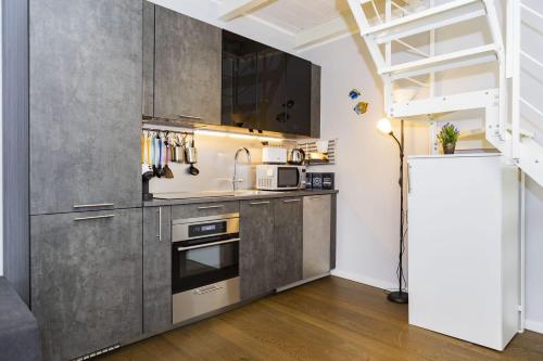 a kitchen with stainless steel appliances and a staircase at Italstay - Disciplini Duplex - 10 min dal Duomo in Milan