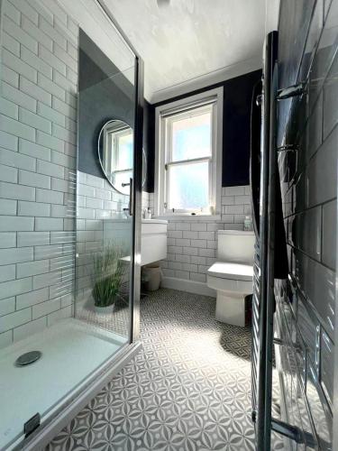 y baño con ducha, aseo y lavamanos. en Modern 2-bed flat in town centre, en Oban