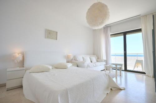 a white bedroom with a bed and a view of the ocean at CAELIA Residence ap 2 camere in Mamaia