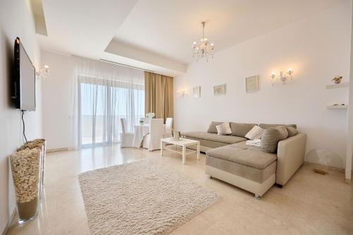 uma sala de estar com um sofá e uma televisão em CAELIA Residence ap 2 camere em Mamaia