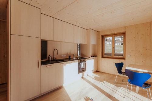een keuken met witte kasten en een tafel en stoelen bij Haus W in Schruns