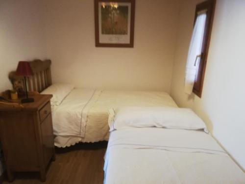 een slaapkamer met 2 bedden en een dressoir en een bed bij Pequeño adosado de montaña con terraza in Villanova