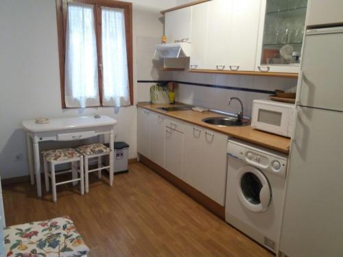 a small kitchen with a sink and a microwave at Pequeño adosado de montaña con terraza in Villanova