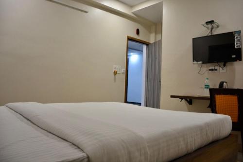 a bedroom with a bed and a flat screen tv at Hotel Royal Residency in Kolkata