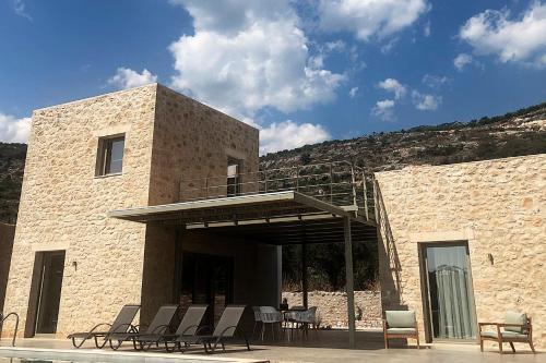 a building with chairs and a balcony with a patio at Riverstone Villas with private pools in Levktron