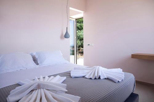 a bedroom with a bed with white towels on it at Riverstone Villas with private pools in Levktron