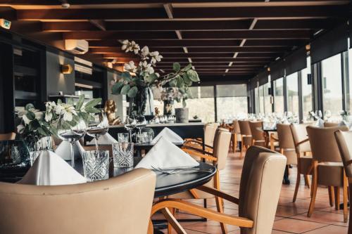 a dining room with tables and chairs and flowers at Van der Valk Hotel Saint-Aygulf in Saint-Aygulf