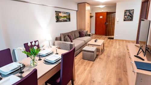 a living room with a table and a couch at Centrum Krynica Zdrój, Sun & Snow in Krynica Zdrój
