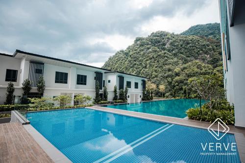 uma piscina em frente a um edifício com uma montanha em Ipoh Tambun Lost World Onsen by Verve em Tambun
