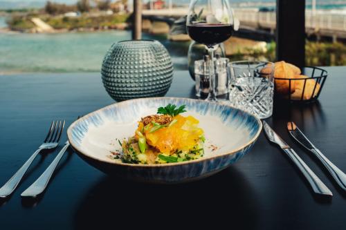 a plate of food on a table with a glass of wine at Van der Valk Hotel Saint-Aygulf in Saint-Aygulf