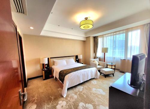 Tianjin Saixiang Hotel في تيانجين: غرفه فندقيه سرير وتلفزيون