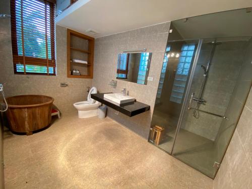 uma casa de banho com uma banheira, um WC e um chuveiro em Green Hill Ba Vi Venuestay em Ba Vì