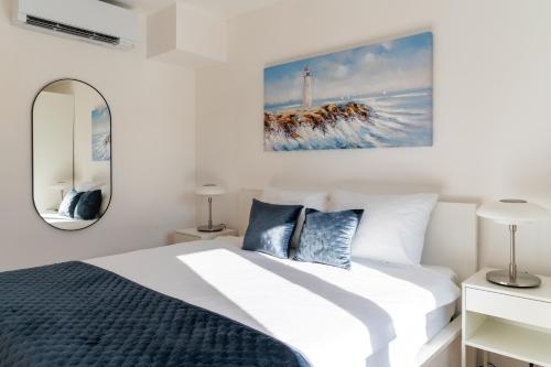 Habitación blanca con cama y espejo en Pepper Penthouse - Luxurious Duplex Apartment, 50m from the Bacvice sand beach en Split