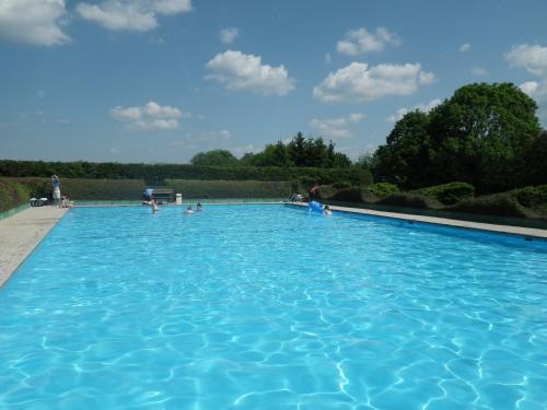 a large blue swimming pool with people in it at Ferienhaus Freilingen in Blankenheim
