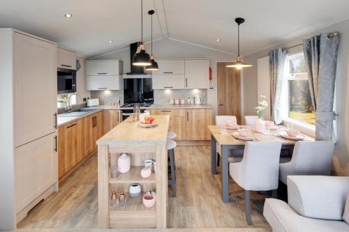 a kitchen with a table and a dining room at Presthaven Resort Haven Luxury 2023 Caravan in Prestatyn